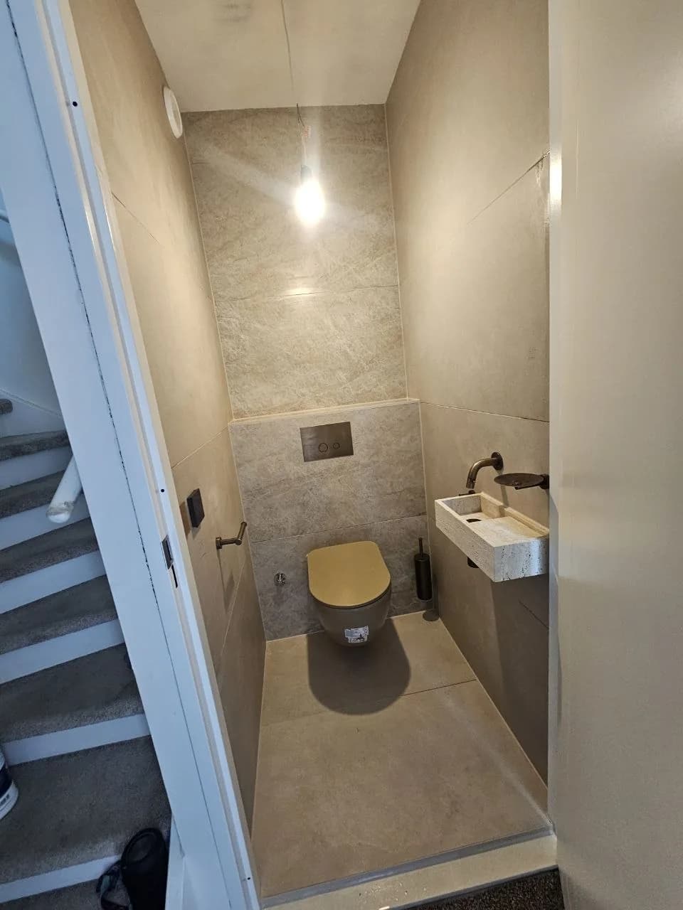 Toilet room with wall-hung toilet and small basin
