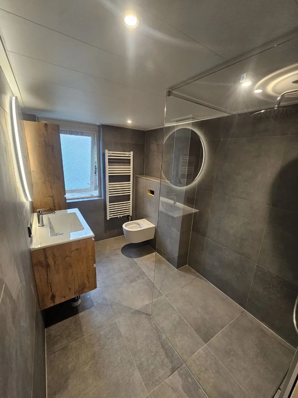 Bathroom with walk-in shower, wooden vanity and large-format tiles